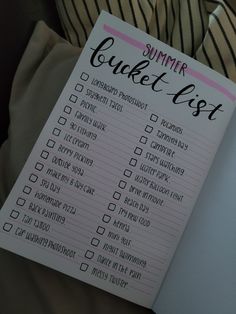 a pink and black checklist sitting on top of a bed