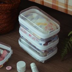 three plastic containers are stacked on top of each other and one container is filled with various items