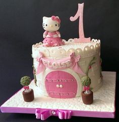 a hello kitty birthday cake with pink decorations and a princess's castle on top