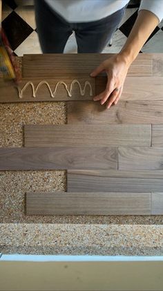 a person standing on top of a wooden floor next to a tile flooring design