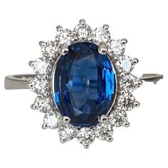 Offered in new condition,18 kt ring in white gold, with an oval cut sapphire (beautiful colour) of 1.65 ct. The sapphire is surrounded by an entourage of 16 brilliant cut diamonds, approx. 0.48 ct in total, quality E/F/VVS/VS. ALGT certificate is included. Gold grade: 18 kt (marked). Natural sapphire: 1.65ct. Natural diamonds: approx 0.48 ct E/F/VVS/VS Ring head size: approx. 15 mm x 21 mm Ring size: 17.75mm / 7/1/2 Weight: 3.82 grams Contemporary Engagement Rings, Gold Flower Ring, Modern Engagement Rings, Diamond Cocktail Rings, European Cut Diamonds, White Gold Ring, Natural Sapphire, Sapphire Diamond, Brilliant Cut Diamond