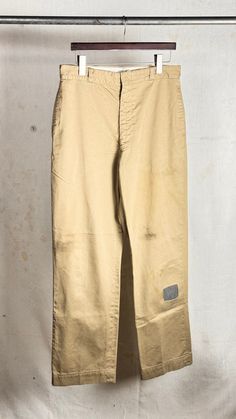 An authentic vintage pair of twill chino trouser pants. US military issued. four pocket style. zip fly. regular relaxed fit. wide straight leg. starched and crispy. new stripe denim knee and back leg patch repairs. era : 1960s material : cotton color : khaki *color may vary slightly in photos than in person condition : distressed , visible signs of age and wear as seen in photos including stains, marks, repairs, and other patina size : ignore tag, please compare measurements below actual garment measurements : waist : 33" rise : 13" hip : 42" inseam : 31.5" - - - - - - - - - - - - - - - - - - - - - - - - - - - - - - - - - - - - - - - -  INTERNATIONAL SHIPPING AVAILABLE UPON REQUEST Craft Union does NOT accept returns or exchanges, all items are FINAL SALE Please consider the following prio Vintage Straight Leg Cargo Pants For Streetwear, Military Style Wide Leg Cotton Work Pants, Vintage Cotton Cargo Pants With Patch Pockets, Vintage Straight Leg Cargo Pants With Patch Pockets, Vintage Pants With Patch Pockets For Streetwear, Vintage Cotton Straight Leg Cargo Pants, Vintage Straight Leg Cotton Cargo Pants, Cotton Vintage Straight Leg Cargo Pants, Vintage Wide Leg Cargo Pants With Patch Pockets