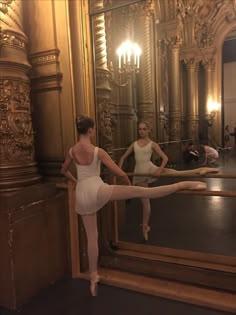 two ballerinas standing in front of a mirror