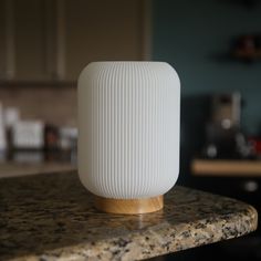 a white vase sitting on top of a counter next to a wooden stand in a kitchen