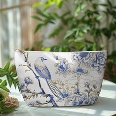 a blue and white bag sitting on top of a table next to some green plants