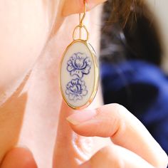 These porcelain earrings have been hand carved, and the drawing is also carved in, so each blue and white floral depiction is a bit unique. A lovely and classic statement earring that is surprisingly light in weight. Custom designed and framed in 14/20k gold-filled hardware, these gold earrings bring some modern blues to something with a bit more history. Porcelain stone piece is 1 1/4 inch in length Eclectic Earrings, Broken Porcelain, Porcelain Jewellery, October Jewelry, Porcelain Handmade, Faberge Jewelry, White Ceramic Tiles, Porcelain Earrings, Broken China