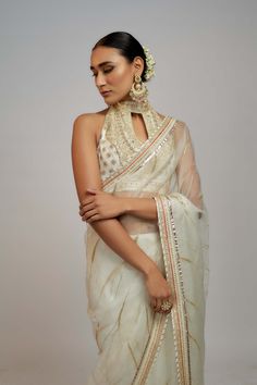 Editor's Note Radiate timeless beauty in this beautiful organza sari set, where subalpine detailing paired with a halter neck blouse creating a captivating look for special occasions. The blend of traditional craftsmanship and modern sensibilities makes it a must-have for those seeking a perfect balance between traditional yet evergreen style. Transitional Party Organza Pre-draped Saree, Elegant Organza Blouse Piece For Designer Wear, Elegant Georgette Saree For Transitional Season, Elegant Chanderi Pre-draped Saree For Celebration, Traditional Drape Organza Blouse For Wedding, Elegant Organza Blouse Piece For Festive Occasions, Elegant Organza Blouse Piece For Festivals, Festive Bollywood Organza Blouse, Elegant Organza Blouse Piece For Diwali