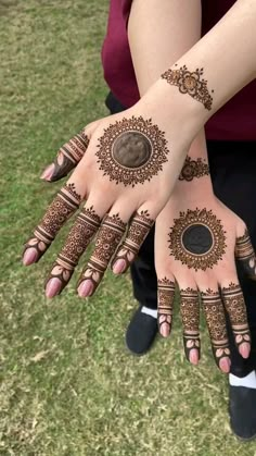 two hands with henna designs on them