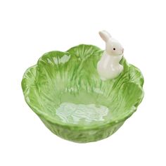 a green bowl with a small white rabbit in it's center and the base is made out of glass