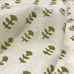 a white fabric with green leaf designs on it's side and the bottom half of its print