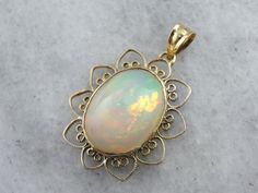 This Mid Century, simple pendant is a great frame for the outstanding Ethiopian Opal gem that we've set at the center. This is a wonderful stone, filled not only with greens and oranges, but also with a rare, pink glow at the center! The radiant style of the frame certainly brings out the glow of the opal! This pendant does not come with the chain shown. Please feel free to contact us, we will help you find the perfect chain for your style and budget! Metal: 14K Yellow Gold Gem: Ethiopian Opal 8 Luxury Ethiopian Opal Jewelry Oval Cabochon, Luxury Ethiopian Opal Pendant Jewelry, Simple Pendant, The Glow, Opal Pendants, Opal Jewelry, Oval Cabochon, Jewelry Lover, Eternity Bands