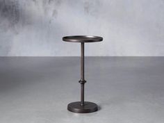 a round table with a metal stand on it's side, against a grey background