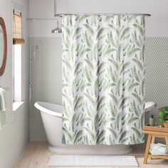 a white bath tub sitting under a bathroom window next to a wooden stool and mirror