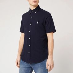 This navy short-sleeved shirt by Polo Ralph Lauren is detailed with a buttoned collar and a central placket with contrasting white buttons. The forever investment is completed with an embroidered polo player logo on the chest. Classic Short Sleeve Button-up Shirt With Snap Buttons, Short Sleeve Polo Shirt For Work, Short Sleeve Polo Shirt With Placket For Work, Cotton Polo Collar Shirt With Button Closure, Short Sleeve Polo Shirt With Button Closure For Work, Navy Short Sleeve Polo Shirt For Work, Fitted Polo Shirt With Short Sleeves, Blue Polo Shirt With Button Closure And Spread Collar, Cotton Polo Shirt With Button Closure And Short Sleeves