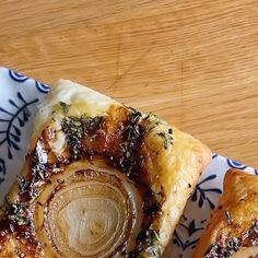 two pieces of pizza sitting on top of a blue and white plate