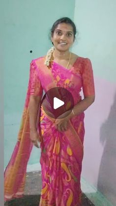 a woman in a pink sari is holding a fan and smiling at the camera