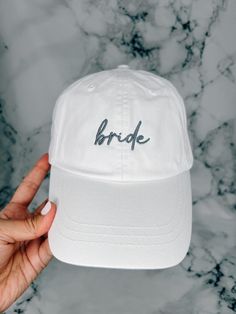 the bride embroidered hat in white is held up to show it's brim