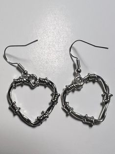 Barbed Wire Heart Earrings    Silver coloured heart shape charms with a look of barbed wire.  Silver coloured earring hooks.  24mm by 24mm by 2mm.  Brand new item in it's original packaging.  Check out the photos for a great view of the items.  Age 6+. Wire Heart Earrings, Barbed Wire Heart, Wire Heart, Grunge Jewelry, Goth Earrings, Goth Grunge, Rock Punk, Design Statement, Statement Jewellery