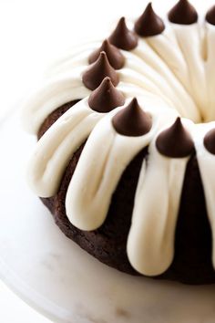 a cake with white frosting and chocolate sprinkles sitting on a plate