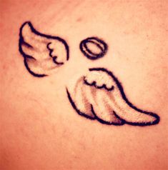 an angel tattoo on the back of a woman's upper arm, with two wings