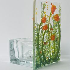 a glass vase with flowers painted on it