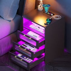 a night stand with three drawers and two lights on the side, next to a couch