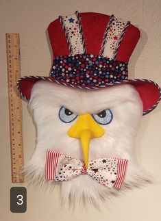 an eagle wearing a red, white and blue hat with a bow tie on it's head