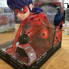 a lady bug figurine sitting on top of a table next to a box