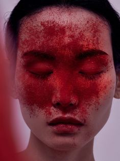 a woman's face covered in red powder