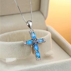 Beautiful Synthetic Blue Opal Cross With Sapphire Color Accent Stones Blue Spiritual Birthstone Jewelry, Blue Clavicle Chain Jewelry As Gift, Elegant Blue Cross Jewelry, Blue Clavicle Chain Jewelry For Gifts, Blue Clavicle Chain Jewelry Gift, Light Blue Birthstone Pendant Jewelry, Spiritual Light Blue Jewelry For Gift, Light Blue Round Sterling Silver Necklace, Light Blue Sterling Silver Round Necklace