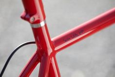 a close up of a red bike frame with writing on the front and rear end