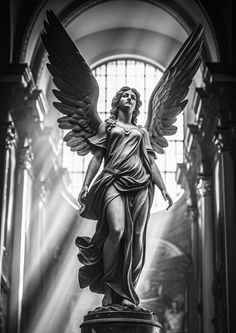 an angel statue in the middle of a church with sunlight streaming through it's windows