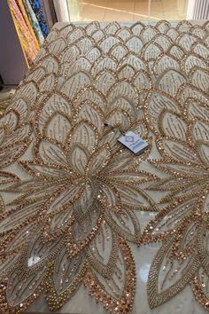 an elaborately designed bed spread with gold sequins and beads on it's edges