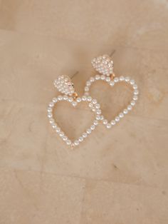 Get ready to add some heart to your outfit with these earrings! These double heart earrings are adorned with delicate pearl beading. Details Post Back Gold Pearl Beading Heart Dangle 1.5 Inches Long 1 Inch Wide Lead & Nickel Free Pearl Beading, Color Picker, Double Heart, Cream And Gold, Gold Pearl, Heart Earrings, Free Coloring, Pearl Beads, My Heart