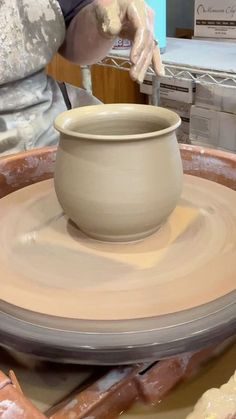 a person is making a pot on a potter's wheel