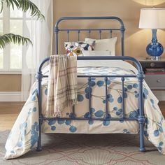 a blue metal bed frame in a bedroom