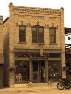 an old fashioned car parked in front of a building