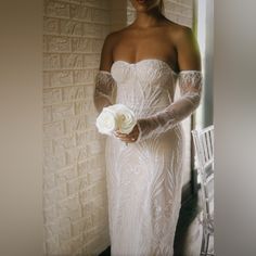 a woman in a white dress holding a flower