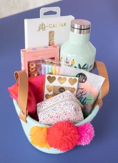 a basket filled with lots of items sitting on top of a blue table next to a bottle