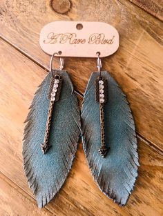 two pairs of blue leather feather earrings with crystal stones on the bottom and silver earwires