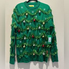 a green sweater with christmas decorations on it