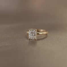 a gold ring with a square cut diamond