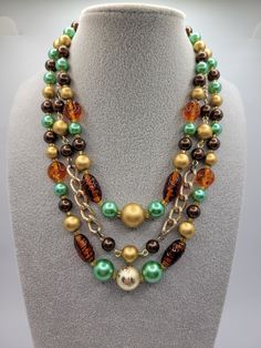 This is a gorgeous mid-century vintage triple strand necklace.  ATTRIBUTES - Circa 1950s - Marked JAPAN on hook clasp - Embossed glass beads and assorted metal beads - Goldtone chain - Rich fall colors - Beautiful condition with minor wear consistent with age MEASUREMENTS - 17" long, but could easily add an extender for modern wear CONDITION - Excellent GENTLY USED vintage condition with minor wear MORE BEAUTIFUL NECKLACES - https://www.etsy.com/shop/SiftedandRefined?section_id=32269322 BACK TO OUR STOREFRONT - https://www.etsy.com/shop/SiftedandRefined SPECIAL NOTE - Props such as trays, display stands, jewelry boxes, rulers, or coins are not included SHIPPING - We package items in organza or velvet gift bags - included FREE - Orders ship in a padded mailer or small box suitable for USPS Cheap Vintage Beaded Necklaces With Spacer Beads, Vintage Colorful Beads Double Strand Necklace, Vintage Multi-strand Beaded Chain Necklaces, Vintage Double Strand Colorful Beads Necklace, Vintage Multi-strand Layered Necklace For Gifts, Vintage Double Strand Beaded Chain Jewelry, Vintage Double Strand Beaded Necklaces For Jewelry Making, Vintage Double Strand Beaded Chain Necklaces, Vintage Multi-strand Beaded Chain Jewelry