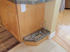 a kitchen sink sitting in the middle of a wooden floor