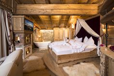 a large bed sitting inside of a bedroom next to a bathtub in a room