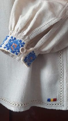 a white shirt with blue and orange designs on it