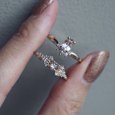 a woman's hand holding two engagement rings