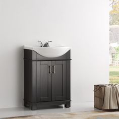 a white sink sitting next to a wooden cabinet in a room with a rug on the floor