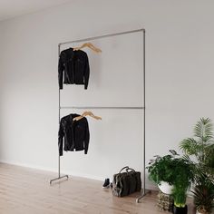 an empty room with clothes hanging on the rack and a handbag next to it