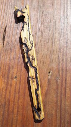 a wooden object that looks like it has been carved to look like an old knife